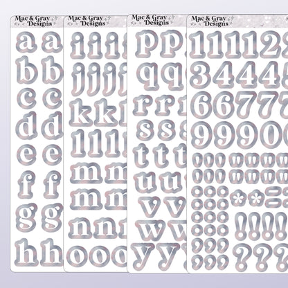 A mockup of four journalling sticker sheets containing letters and numbers. Each letter or number is white, surrounded by a light celestial style print. Each sticker is individually cut around the character.